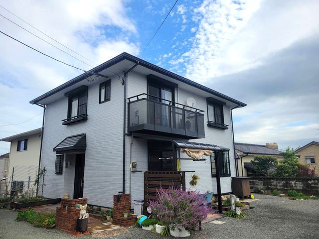 塗装が完了した白い2階建て住宅と青空